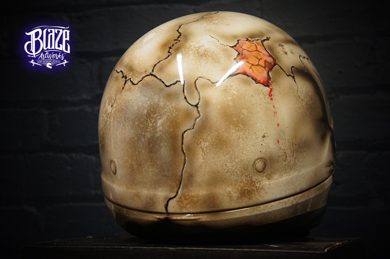 Realistic cracked skull motorcycle helmet design with brown weathered bone texture, orange-red interior details, anatomical airbrush art